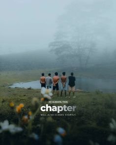 four men standing in front of a body of water on a foggy, misty day