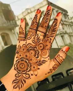 a woman's hand with henna tattoos on it