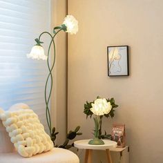 a living room filled with furniture and flowers in vases on top of small tables