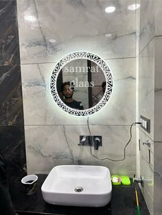 a bathroom with a sink, mirror and marble counter top in front of a man's face