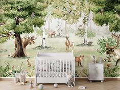 a baby's room with a wall mural featuring animals and trees