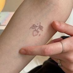 a person with a small tattoo on their arm holding onto her hand and finger,