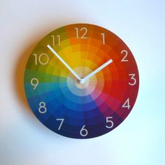 a clock with the colors of the rainbow on it's face and numbers below