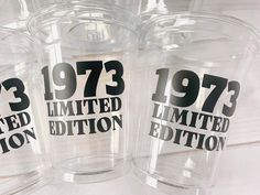 three clear plastic cups with black numbers and the words 1971 limited written in white on them