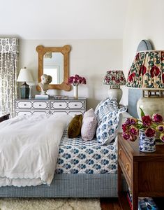 a bed room with a neatly made bed and flowers on the nightstand next to it