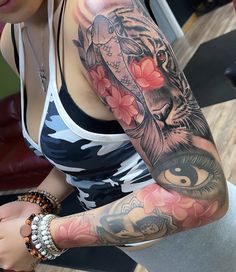 a woman with a tiger and flower tattoo on her arm is looking at the camera