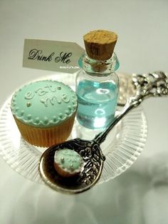 two cupcakes on a glass plate with a bottle of water and a spoon