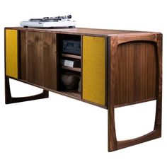 an old record player sitting on top of a wooden entertainment center with yellow paneling