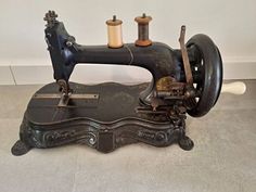 an old sewing machine with two spools of thread