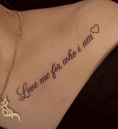 a woman with a tattoo saying love me for who i am on her back shoulder