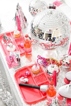 a table topped with pink trays and disco balls