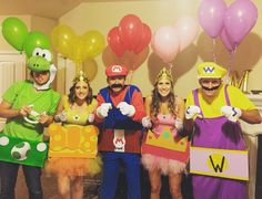 some people are dressed up as mario and luigi in costume for a party with balloons