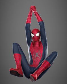 a spider - man hanging from a string with his hands in the air, while he is