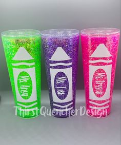 three different colored plastic cups with writing on them