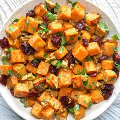 a white plate topped with sweet potatoes and cranberries