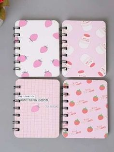 three notebooks with different designs on them sitting next to a cupcake and flower