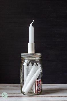 a glass jar filled with toothbrushes on top of a wooden table