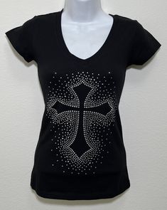 Fabric comprised of 95% cotton and 5% spandex.  Handmade rhinestone t-shirts made in the United States with quality rhinestones. Machine Washable. T-shirt is a fitted V-neck cap sleeve. Size Range:         XXS = 2         XS = 4         S = 6         M = 8         L = 10         XL = 12 Fitted Black T-shirt With Rhinestones, Embellished Fitted Cotton T-shirt, Fitted Cotton Embellished T-shirt, Cotton T-shirt With Rhinestones And Short Sleeves, Cotton Short Sleeve T-shirt With Rhinestones, Cotton T-shirt With Rhinestones Short Sleeve, Black V-neck Tops With Rhinestones, Fitted V-neck Top With Rhinestones, Black V-neck Top With Rhinestones