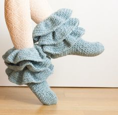 a woman's legs wearing blue knitted socks with ruffles on them