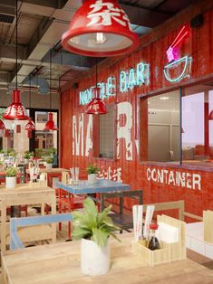 the interior of a restaurant with wooden tables and chairs in front of red painted walls