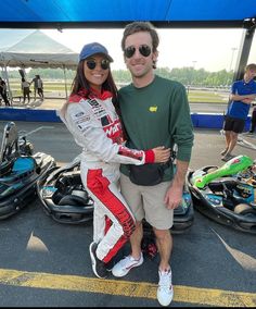 a man and woman standing next to each other in front of snowmobiles at an event