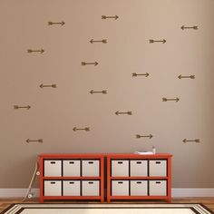 an empty room with several arrows on the wall and drawers in front of it,