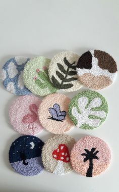 several different types of coasters are arranged on a white surface with leaves and mushrooms