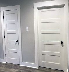 two white doors in the middle of a room