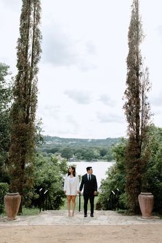 a man and woman standing in front of some trees