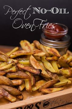 french fries on a cutting board with ketchup in the background and text overlay that reads perfect no - oil oven fries