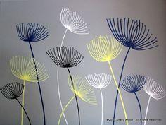 some white and blue flowers on a gray wall in front of a grey background with the words'dandelion'written below it