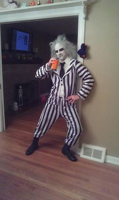 a man dressed as the joker holding an orange cup