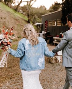 a bride and groom walking down the road holding hands