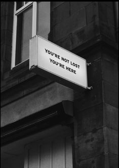 a sign on the side of a building that says you're not lost, you're here