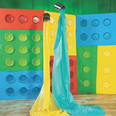 a colorful room with several colored blocks on the wall and an umbrella in the middle