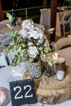 a wooden table topped with a vase filled with flowers next to a number 22 sign