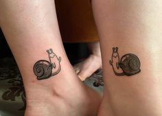 two people with matching tattoos on their legs, one has a snail and the other has a cat