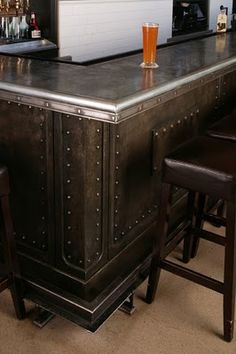 a bar with several stools and bottles on it