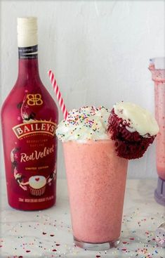 a cupcake in a glass next to a bottle of bailey's red velvet