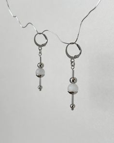 These futuristic earrings are made from stainless steel and feature frosted white jade beads. DIMENSIONS & FEATURES: ▪️ Materials: jade gemstone, stainless steel (hypoallergenic and maintains its appearance over time) ▪️ Length: 5 cm / 2 inch ▪️ Color: silver metal, frosted white ▪️ Weight of one earring: ~2 g / ~0,07 oz PACKAGE & SHIPPING: ▪️ ECO-friendly packing. I draw inspiration from nature and strive to minimize environmental impact. ▪️ FREE shipping ▪️ Ready to ship in 1-2 business days ▪ Hypoallergenic White Metal Earrings, White Minimalist Metal Jewelry, Minimalist White Metal Jewelry, White Hypoallergenic Stainless Steel Earrings, Modern Handmade Stainless Steel Earrings, Hypoallergenic White Stainless Steel Earrings, White Stainless Steel Earrings For Gift, Modern White Pierced Earrings, Modern White Nickel-free Earrings