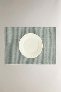 a white plate sitting on top of a blue and white place mat