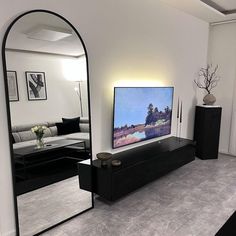 a large flat screen tv sitting on top of a wooden stand in a living room