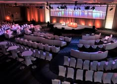 an empty auditorium with white tables and chairs