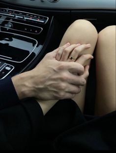 a woman's hands resting on the steering wheel of a car while holding her hand