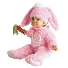 a baby in a pink bunny costume holding a carrot