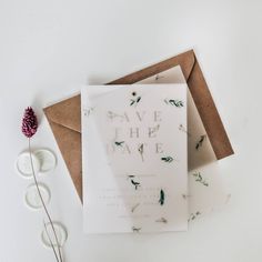 an envelope and some flowers on a table