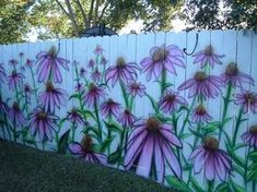 a white picket fence with purple flowers painted on it