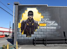 a mural on the side of a building depicts a man wearing a black suit and sunglasses