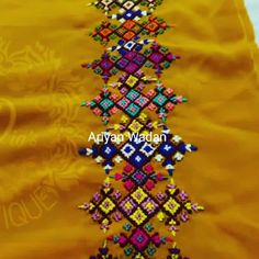 an embroidered yellow cloth with multicolored designs on it and the words afghan wadah written in arabic