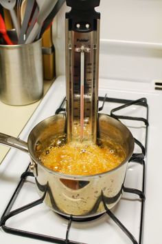 a large pot on top of a stove with a measuring device in it's handle